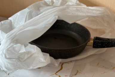 Пакую сковороду в пакет, и нагар легко отлетает ошметками - красуюсь в отражении ИА KrasnodarMedia